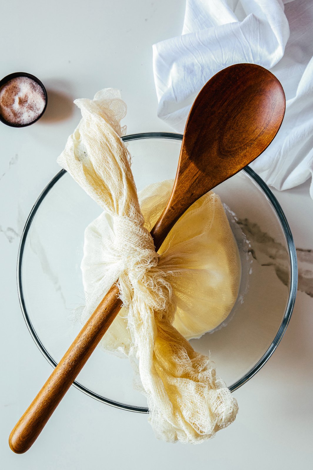 Greek yogurt tied over a spoon that rests across the bowl