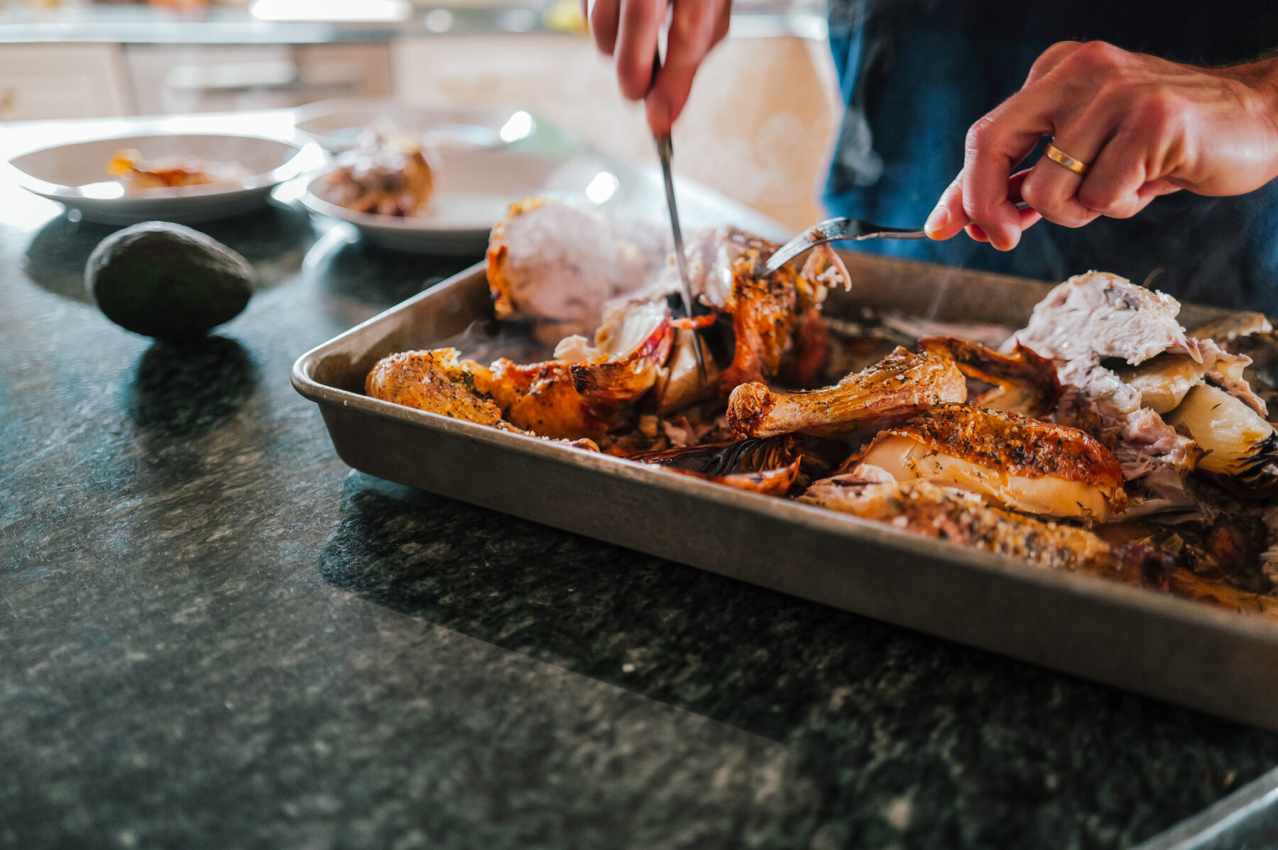 Removing cooked chicken meat from the bones after roasting